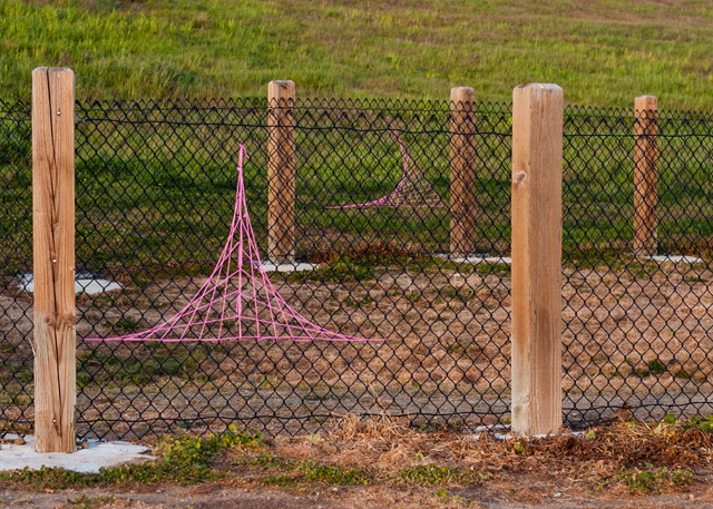 fence yarn bombed with string art